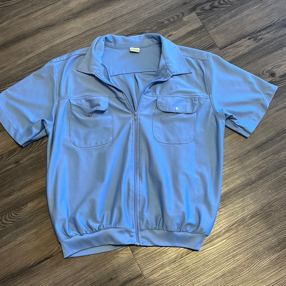 Light weight, blue, short-sleeve zip up with two front button pockets.